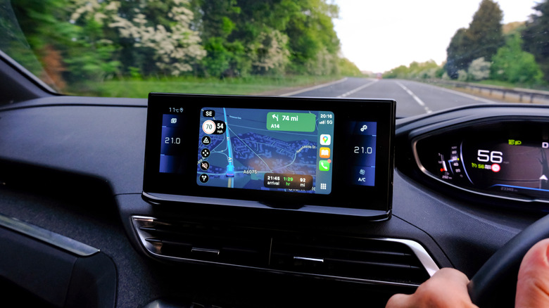 A person driving a car on a highway with Google Maps turned on