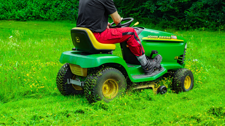 A shot of a man on a John Deer lawn tractor