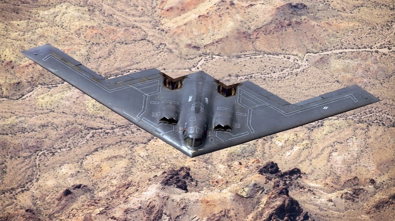 A B-2 Bomber flying over the desert.