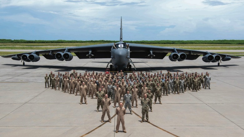 B-52 crew stand in front of aircraft in "V" formation