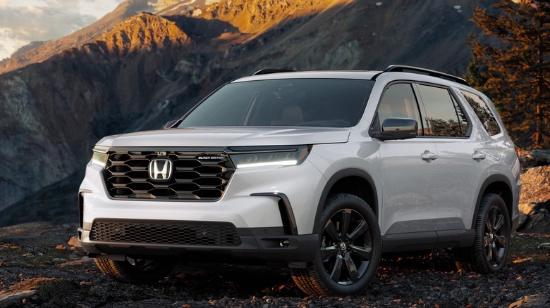 Front-quarter view of a 2025 Honda Pilot Black Edition in white, pictured against a mountain backdrop