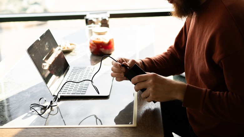 Man connecting power bank to laptop