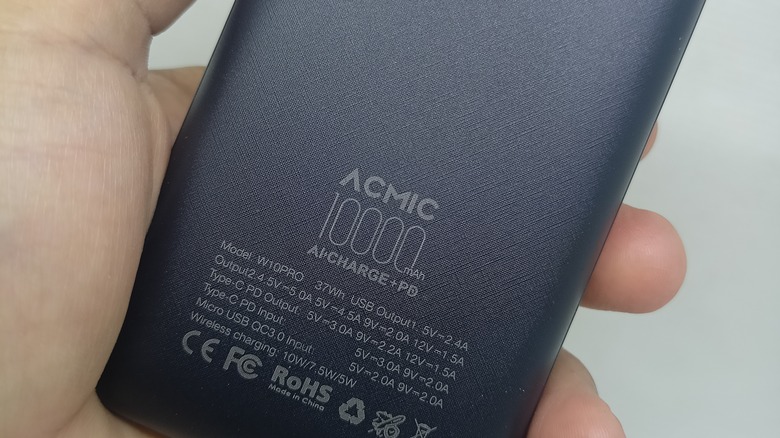 Hand holding power bank showing printed info