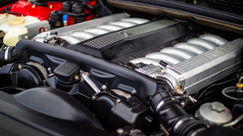 Detailed view of a powerful V12 engine inside a performance car, showing intake manifolds and precision mechanical components.
