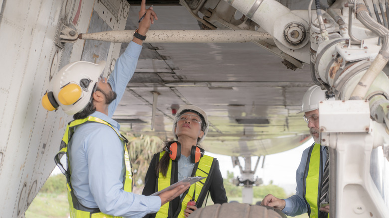 technicians inspecting an airplane