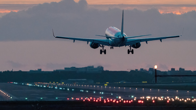 airplane on runway approach at dusk