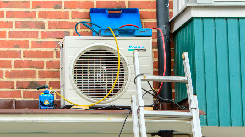 A Daikin air conditioner sits alongside brick wall in process of being fitted.