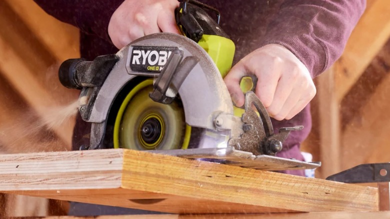 Using a Ryobi circular saw to cut through a thick piece of wood.