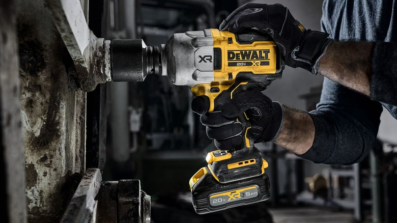 A person using a DeWalt impact wrench.