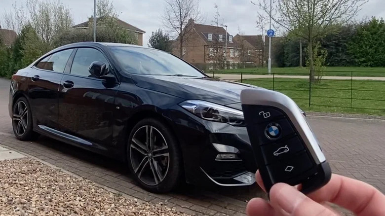 BMW car key fob held in front of vehicle