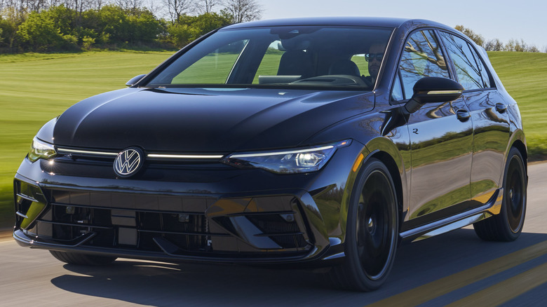 A 2025 Volkswagen Golf R Black Edition being driven on a roadway.