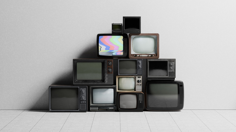 CRT TVs stacked against a white wall
