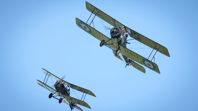 WWI biplane replicas flying in blue skies.
