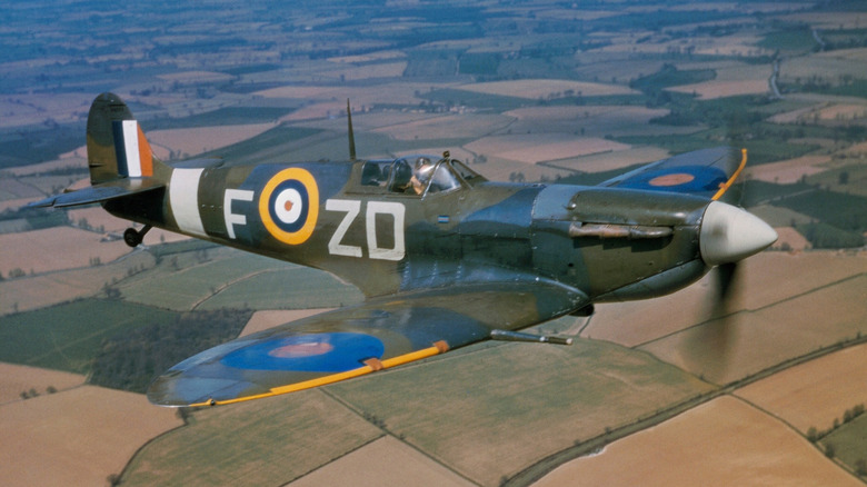 A Spitfire flying over fields.