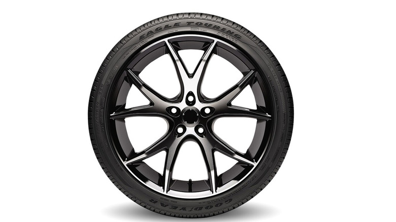Goodyear eagle touring tire on wheel against white background