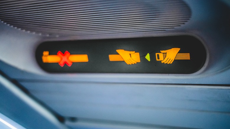 An illuminated no smoking and fasten seatbelt sign on an aircraft.