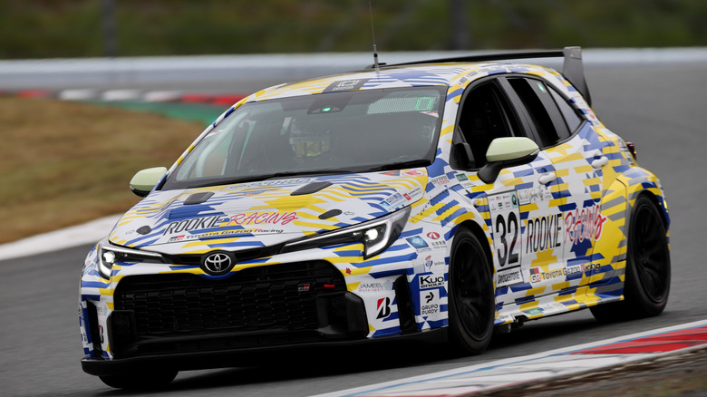 Hydrogen engine-powered Toyota GR Corolla in racing livery driving on-track, front-left view