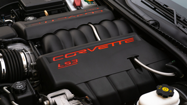 LS3 engine in Corvette engine bay; black covers with red script