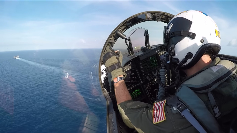 Pilot preparing jet plane for landing on aircraft carrier