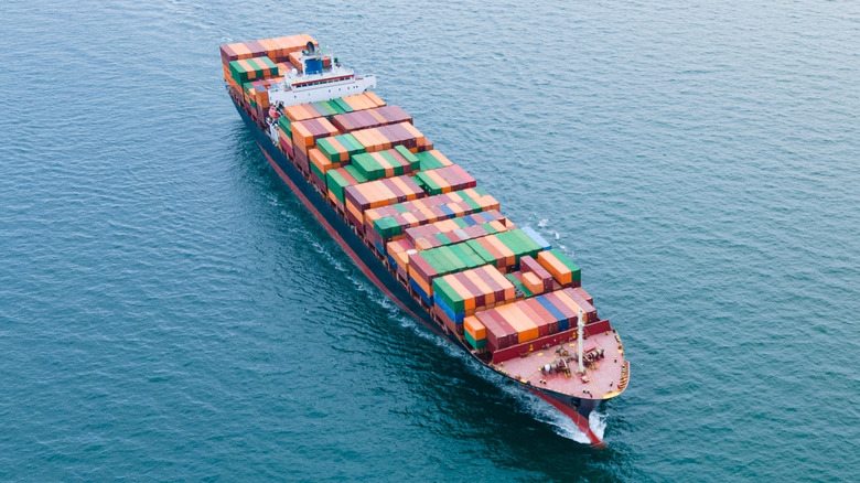 A full cargo ship floating in the ocean.