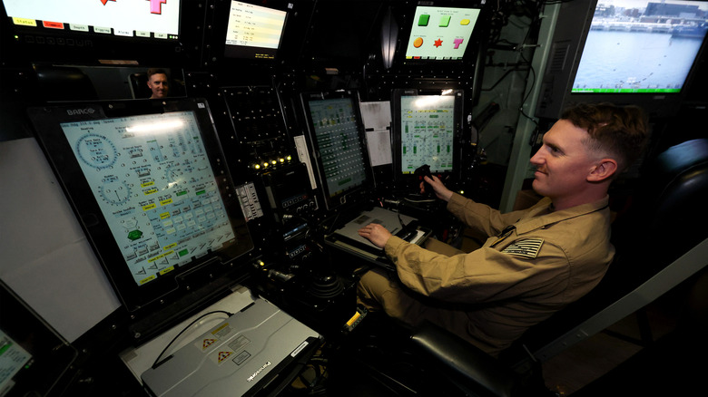 Sailor navigating attack submarine from a control station