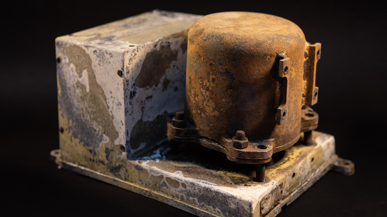 Damaged Aircraft flight data recorder on black background. Black Box with extensive fire damage after an accident or production testing of equipment