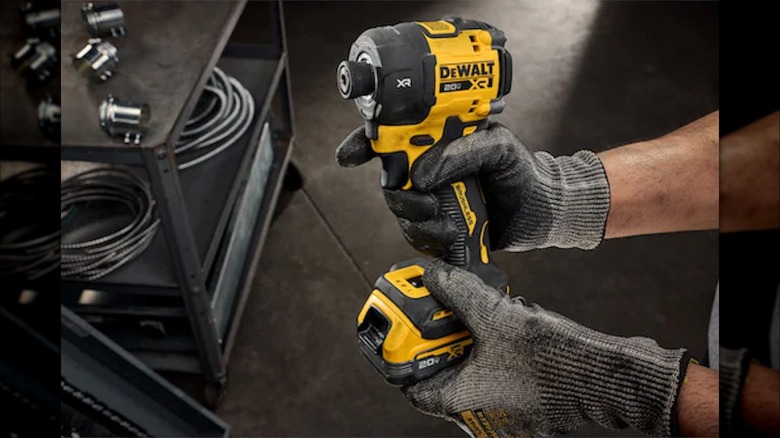 Two hands holding a 20V Max XR ¼-inch Quiet Hydraulic Impact Driver