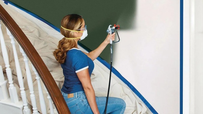 woman using Avanti airless sprayer on wall