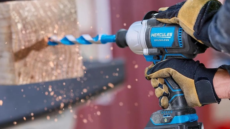 A person using a Hercules impact wrench to drill into wood.