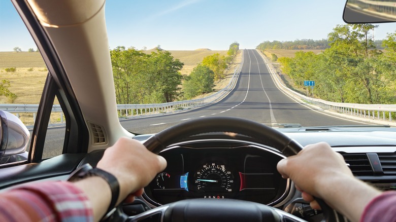 First person view of a person driving a car on a highway