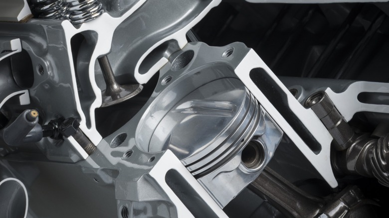 A cutaway view of an internal combustion engine showing the top of a piston and other components