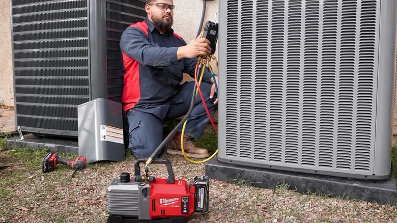 Technician using a M18 5 CFM Fuel Vacuum Pump on HVAC unit