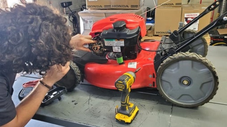 A Northern Tool technician working on a lawn mower engine