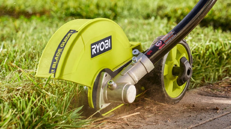 Close up of Ryobi Expand-It Universal Edger Attachment along pavement