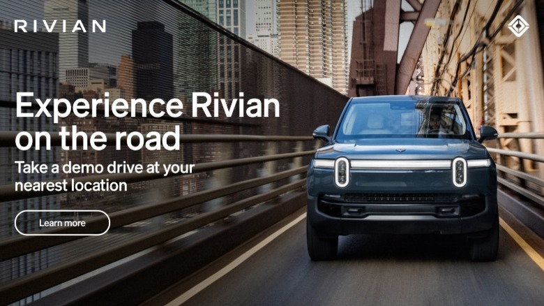 Blue Rivian EV vehicle driving in a city with text "Experience Rivian on the Road"