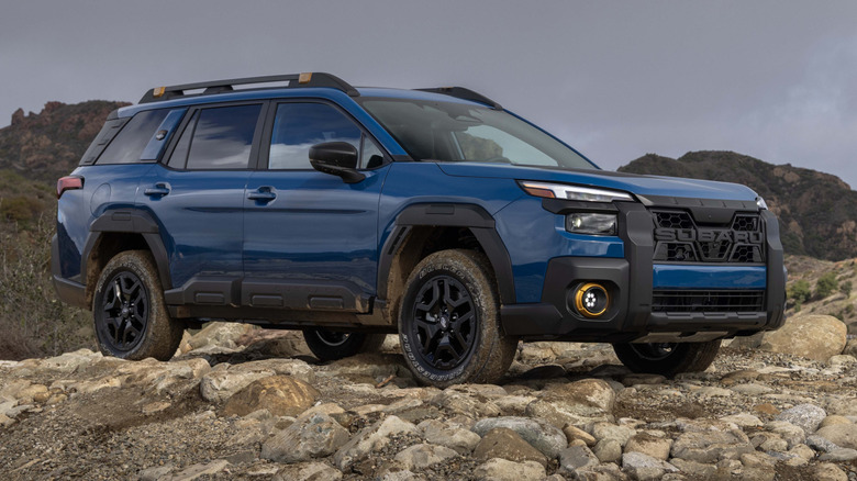 The 2026 Subaru Outlook in the Wilderness Edition trim parked on a rocky patch, front 3/4 view
