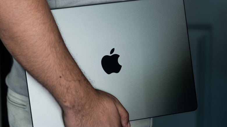 Person carrying a MacBook Pro.