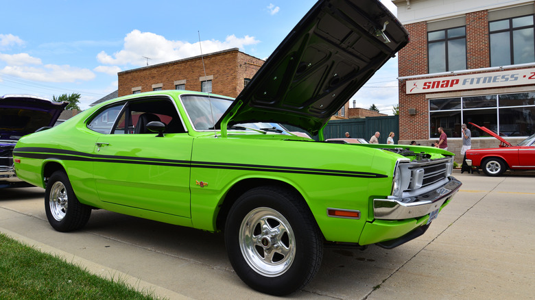 Front 3/4 view of green 1970s Dodge Demon parked at car show.