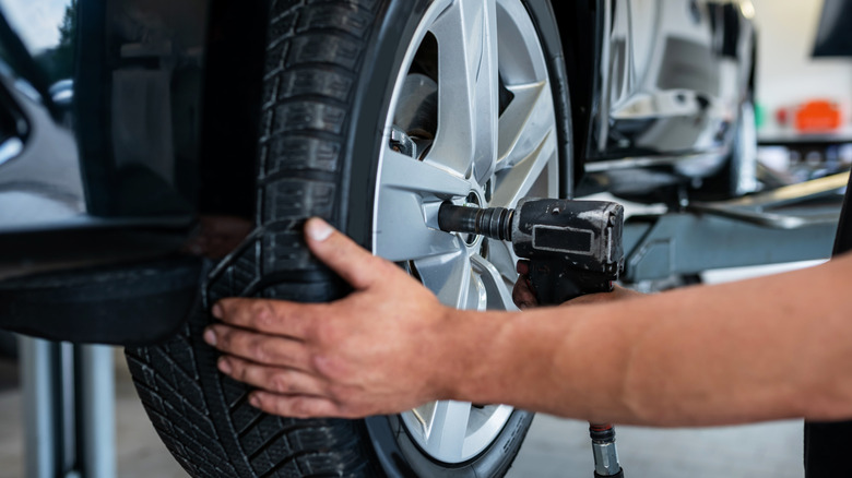 A mechanic changes a tire in a car repair shop