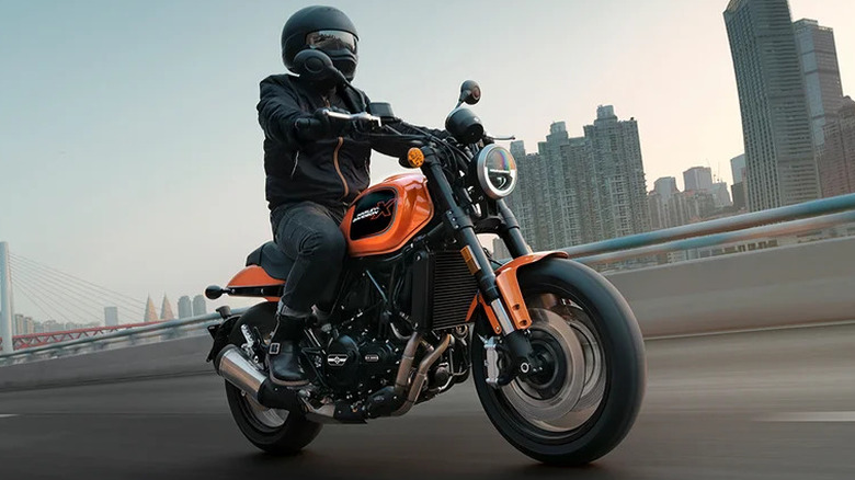 Rider with a helmet riding a Harley Davidson X500 on the road