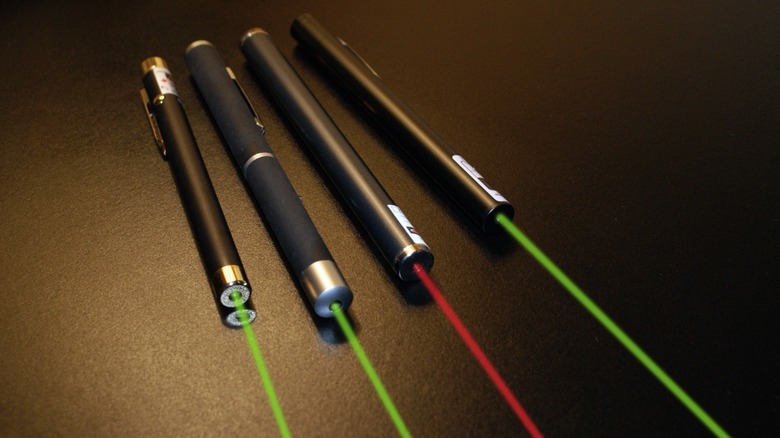 Four commercial laser pointers with three green and one red beam