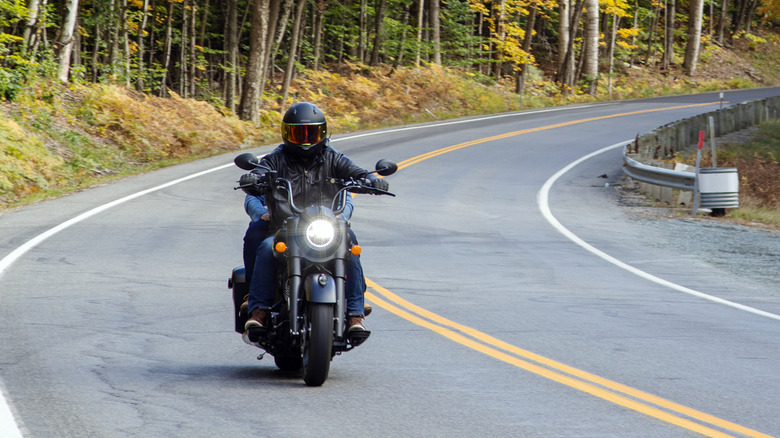 Man riding a motorcyle on a country road