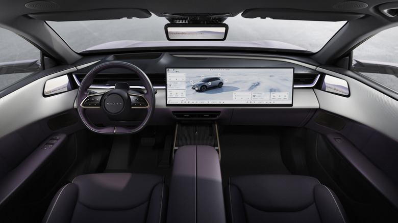 View of Mazda EZ-60 interior, showing the seats, steering wheel, and display screen