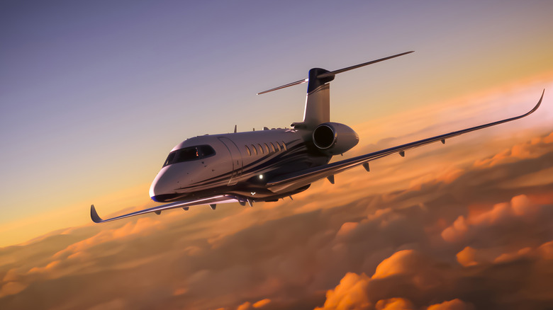 private jet flying at sunset