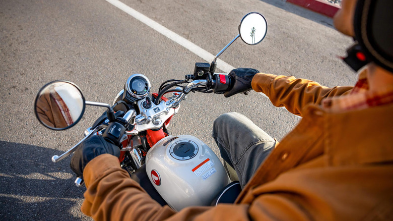 Over-shoulder view of a 2025 red and white Honda Monkey's handlebars