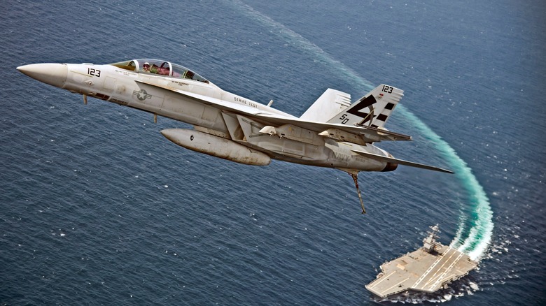 An F/A-18F flying over the USS Gerald R. Ford
