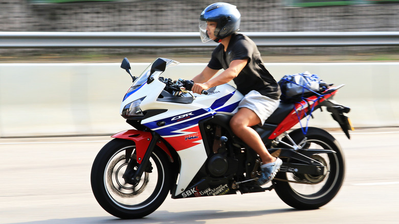 Um motociclista andando de uma motocicleta Honda CBR500R em uma rodovia