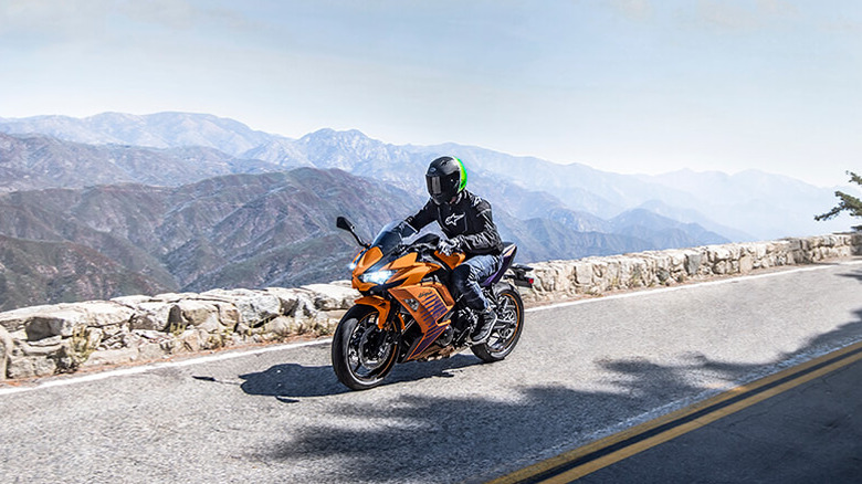 Orange Kawasaki Ninja 650 with mountains in the background
