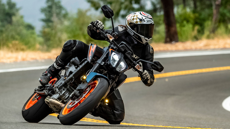 Man riding a 2023 KTM 390 Duke 23 motorcycle travelling on a British road