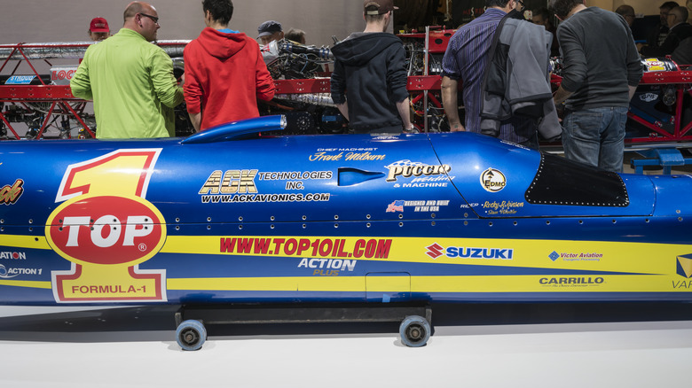 Top 1 Ack Attack motorcycle lifted on dolly, blue and yellow